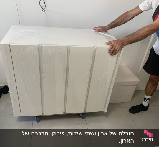 אדם מזיז רהיט עטוף בניילון על גלגלים